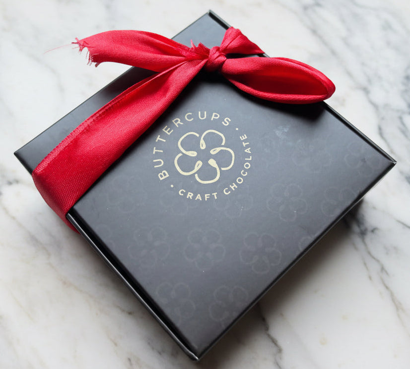 Buttercups Craft Chocolate boxes with red ribbons on a wooden surface